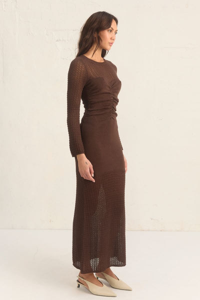 Mon Renn Onika Knit Dress in mahogany. A fitted long-sleeve dress in a viscose blend with ruching at the front, sheer contrast panels, and full body lining.
