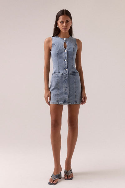 Model wears the SOVERE Studio Etch Denim Mini Dress featuring a sleeveless cut, crew neck with keyhole, and body-contouring panels.