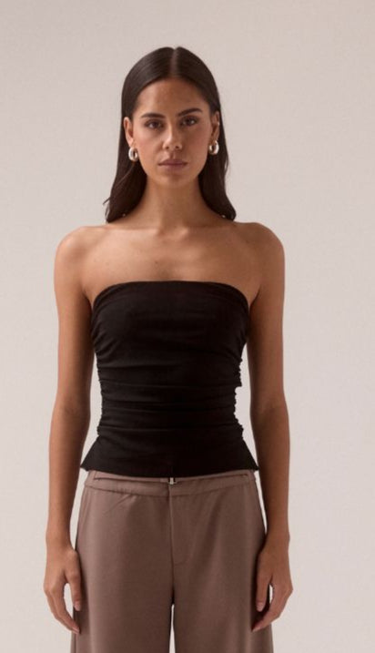 SOVERE STUDIO MYRIAD black ruched strapless top Model front-facing in black strapless top with hands relaxed