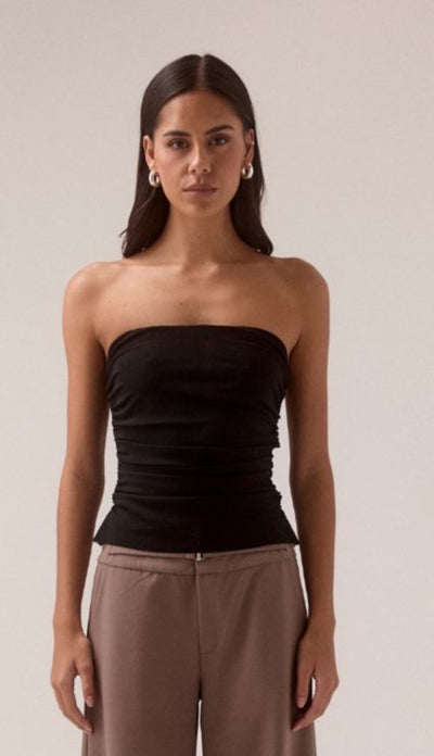 SOVERE STUDIO MYRIAD black ruched strapless top Model front-facing in black strapless top with hands relaxed