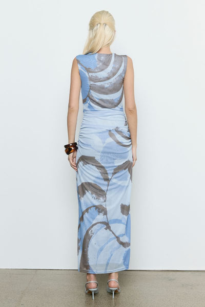 Model wears the SOVERE Whirl Mesh Dress in Slate. Sleeveless printed mesh midi dress with side gathers and boat neckline, fully lined.