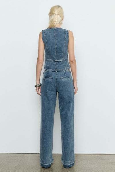 Model wears the SOVERE Dawn Denim Pant in Vintage Blue. Full-length mid-rise jeans with belt and contrast hem detail.