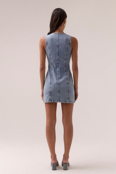 Model wears the SOVERE Studio Etch Denim Mini Dress featuring a sleeveless cut, crew neck with keyhole, and body-contouring panels.