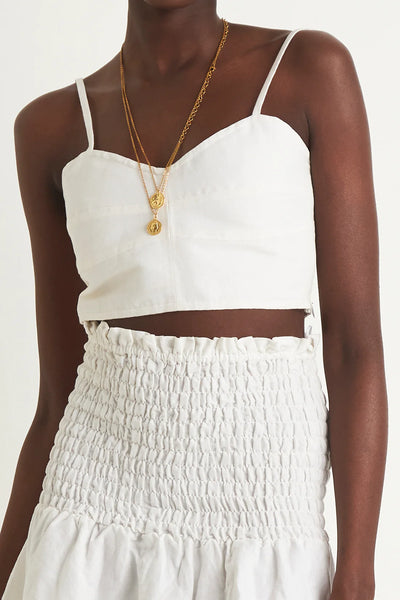 ZERAFIMA The Island Bodice Crop is a cropped and fitted corset top featuring in classic white linen blend. Wear it with Island Paper bag Pant for the complete resort outfit.White Tops