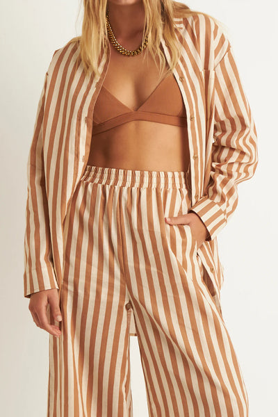 ZERAFIMA The Maple Long Sleeve Shirt is a summer linen blend shirt in tan stripe print. Features include long line silhouette, tortoise shell buttons and relaxed fit. Can also be worn as a shirt dress over swimwear. DETAILS Oversized long line 